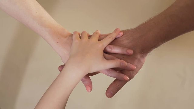 Parents and child making hand stack, teamwork and togetherness, family values