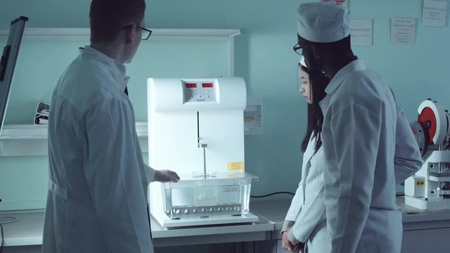 Tutor showing pills solubility tester to the students.