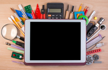 Tablet PC over school supplies or office supplies on school table. Background with school or office...