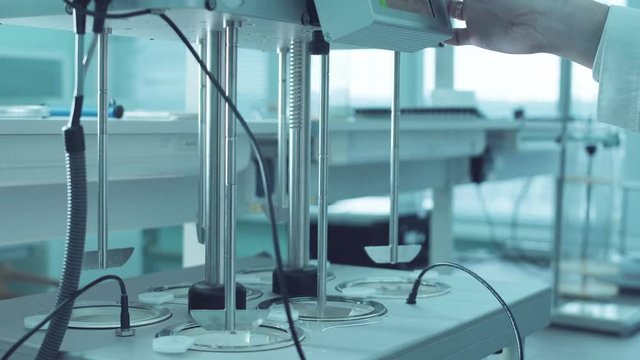 Hand of person putting the settings to the pills solubility tester.