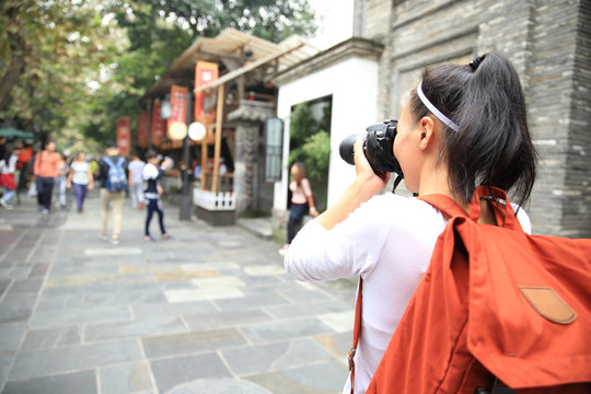 young woman tourist with camera on street in chengdu,china