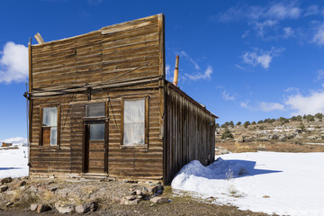Old weathered Ghost Town buildings in the desert during winter with snow.  Ione, Nevada