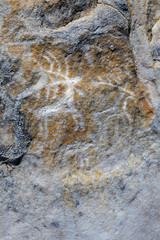 Ancient petroglyphs of running deers, rock paintings of ancient buryat tribe, lake Baikal coast