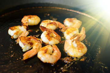 Fried shimps on frying pan, part of salad or another dish, food with light