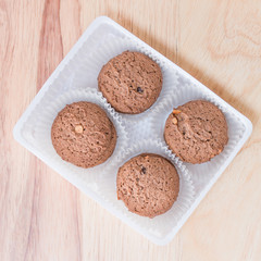 Cookies chocolate in plastic box on wood background