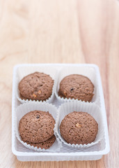 Cookies chocolate in plastic box on wood background