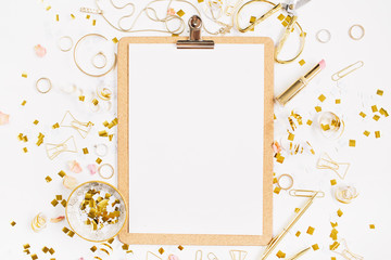 Beauty blog background. Clipboard and gold style feminine accessories pattern. Golden tinsel, scissors, pen, rings, necklace, bracelet on white background. Flat lay, top view.