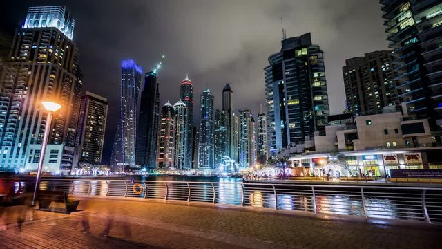  Timelapse of the visitors wander along Dubai Marina(Cayan Tower) at night, UAE
