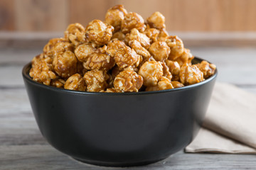 Caramel popcorn on wooden background