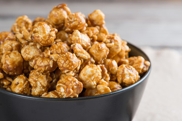 Caramel popcorn on wooden background