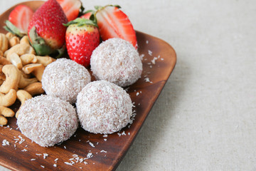 Fototapeta na wymiar Homemade strawberry, date, cashew and coconut bliss ball