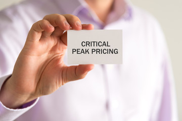 Businessman holding a card with text CRITICAL PEAK PRICING