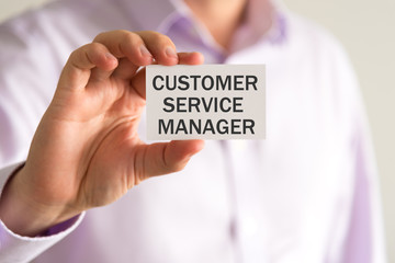 Businessman holding a card with text CUSTOMER SERVICE MANAGER