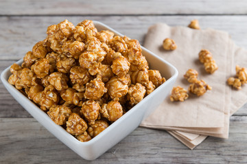 Caramel popcorn on wooden background