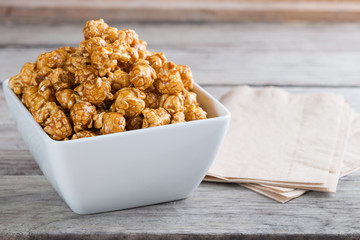 Caramel popcorn on wooden background