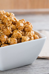 Caramel popcorn on wooden background