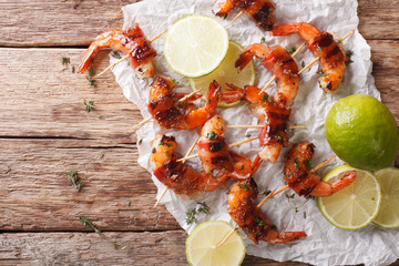 shrimp wrapped in bacon with spices and lime close up. horizontal top view