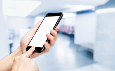 Hand click mobile phone with blur seminar hall room background bokeh light,White screen mock up template for adding your design or your text