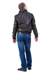 Fototapeta premium Back view of handsome man in jacket looking thoughtfully into th