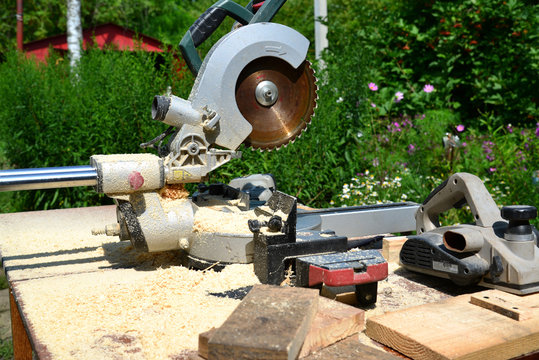 Circular saw and other tools on background of nature in summer