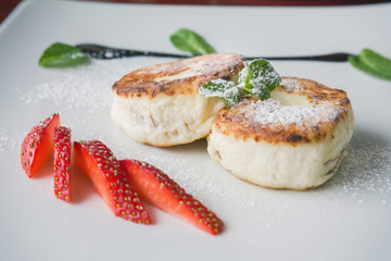 Breakfast dessert - pie with cottage cheese, green sweet sous and strawberry, close up