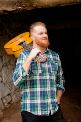 Hipster man with red beard with a guitar