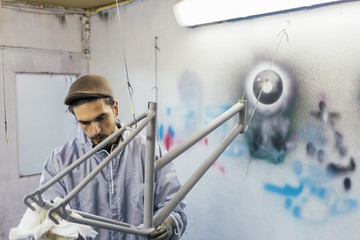 Man in gloves cleaning bikes frame