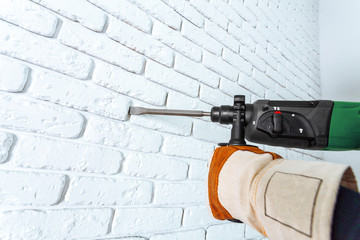 Use hammer drill to drill the wall