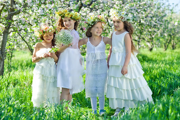 Obraz na płótnie Canvas Little girls in the garden with flowers 