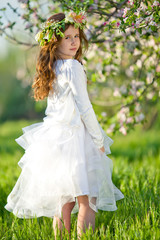 Obraz na płótnie Canvas Little girl in garden with flowers 