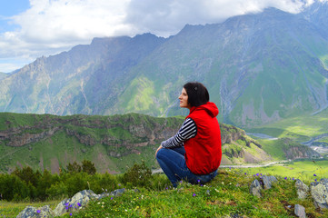 Naklejka premium Happy tourist on the background of the Caucasus mountains