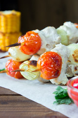 Skewered on wooden sticks tasty pork meat and vegetables mix,
