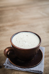 Cup of Cappuccino on Wooden Background.