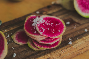 Watermelon Radishes Sliced, Sprinkled with Sea Salt on a wooden background