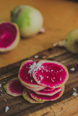 Watermelon Radishes Sliced, Sprinkled with Sea Salt on a wooden background