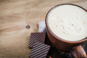 Cup of Cappuccino With a Piece of Chocolate on Wooden Background. Rustic Style. Selective Focus.