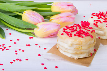 Honey Cake, Sprinkled Red Hearts, with a Bouquet of Tulips on a White Background.