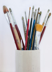 Collection of artist brushes in pottery vase