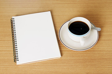 Fototapeta na wymiar Black Coffee cup with notebook on wood table