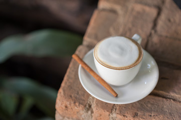 Cup of tasty cappuccino on red brick
