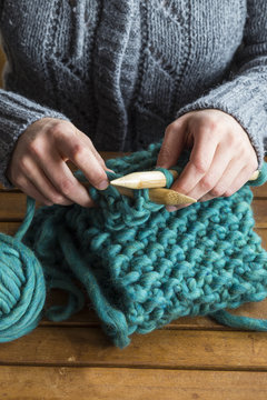 Woman knitting green scarf