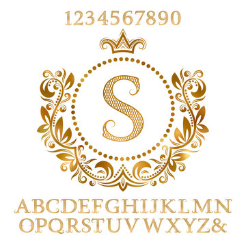 Golden patterned letters and numbers with initial monogram in coat of arms form. Shining font and elements kit for logo design.