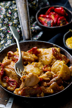 Braised chicken with dried tomatoes in frying pan