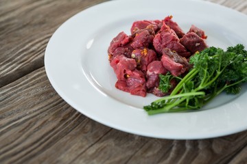 Diced beef and corainder leaves in white plate