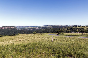  Grassland Against Distand Hills and Blue Sky Landscape
