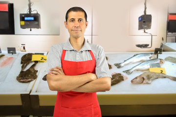 fishmonger in fish shop wearing black apron