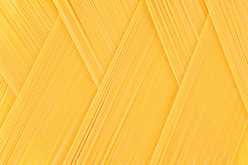 Italian long yellow spaghetti top view  as zigzag abstract pattern background.