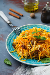 Vegetarian salad with pumpkin, apples and raisins on a dark background. Selective focus.