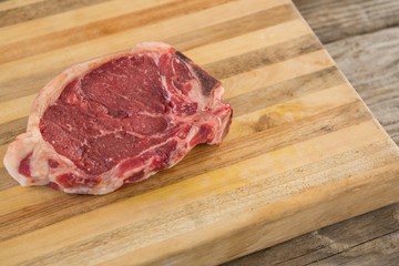 Sirloin chop on wooden tray against wooden background