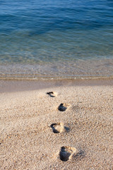 empreintes de pieds dans le sable sur une plage